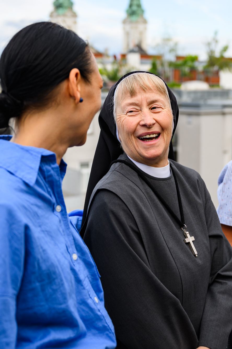 Sr. der Oblatinnen lacht mit einer jungen Frau